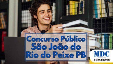 Homem jovem sorridente, de cabelos cacheados e escuros, sentado em frente a um notebook em uma biblioteca ou ambiente de estudos, segurando um livro com uma pilha de outros livros à sua frente, ao fundo há estantes com diversos livros organizados; sobre a imagem, há um destaque em azul com os dizeres “Concurso Público São João do Rio do Peixe PB” e o logotipo “MDC Concursos” no canto inferior direito