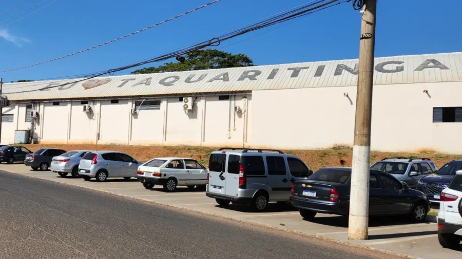 Concurso Taquaritinga SP com fachada de prédio público e carros estacionados na rua