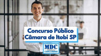 Homem jovem de cabelos curtos e escuros, usando camisa social branca e sorrindo, está de braços cruzados em frente a uma parede de vidro que separa um ambiente de escritório moderno, onde ao fundo duas pessoas trabalham em seus notebooks, a imagem possui uma faixa central com o texto Concurso Público Câmara de Itobi SP e o logotipo da MDC Concursos abaixo