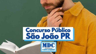 Homem com barba e camisa de veludo cotelê amarela aparece segurando um lápis próximo ao rosto e um caderno aberto, em frente a um fundo verde, sugerindo ambiente escolar ou de estudo; sobre a imagem há um destaque em letras azuis com a frase “Concurso Público São João PR” e o logotipo da MDC Concursos logo abaixo do texto principal
