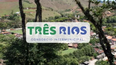 Vista aérea de uma pequena cidade rodeada por montanhas verdes, com o logotipo do Consórcio Intermunicipal Três Rios em destaque no centro da imagem sobre um fundo branco arredondado.