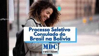 Mulher jovem de cabelos cacheados e expressão sorridente aparece usando mochila e casaco claro enquanto interage com o celular na rua, ao ar livre. Ao centro da imagem há uma faixa com o texto “Processo Seletivo Consulado do Brasil na Bolívia” em letras azuis e, logo abaixo, o logotipo “MDC Concursos”. A imagem transmite sensação de otimismo com a oportunidade divulgada.