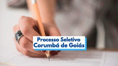 A imagem mostra uma mão segurando um lápis enquanto preenche um formulário ou documento sobre uma superfície plana. A pessoa usa um anel prateado e esmalte vermelho nas unhas. Em destaque na parte inferior da imagem, há uma faixa com os dizeres “Processo Seletivo Corumbá de Goiás” em letras azuis sobre fundo branco, indicando a realização de um processo seletivo no município goiano.