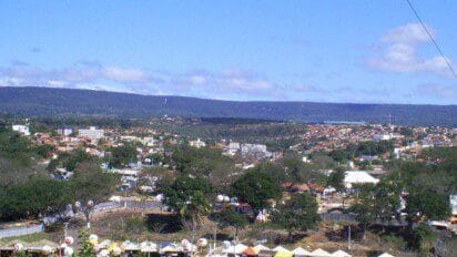 Vista panorâmica da cidade de Crato-CE com área urbana, árvores, construções e serra ao fundo sob céu azul com nuvens. Foto: Aristides Tavares de Figueiredo/Wikipédia