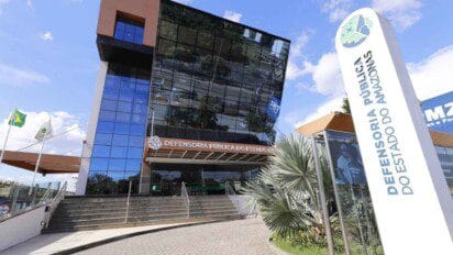 Fachada moderna da sede da Defensoria Pública do Estado do Amazonas com letreiro e totem institucional.