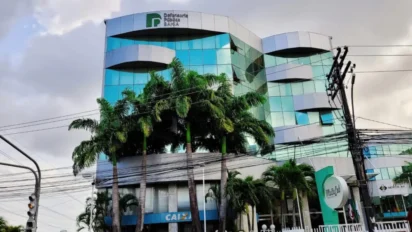 Fachada de prédio moderno da Defensoria Pública do Estado da Bahia com vidros espelhados, palmeiras em frente e logotipo da instituição no topo. Foto: Divulgação/DPE-BA