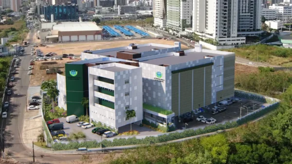 DPE-MA lança concurso com 10 vagas imediatas e salários de R$ 37,7 mil 2 Imagem aérea de um prédio moderno da Defensoria Pública do Estado do Maranhão, com estacionamento ao redor, áreas verdes e edifícios residenciais ao fundo em área urbana. Foto: Divulgação/DPE-MA