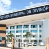 Entrada da Prefeitura Municipal de Divinópolis com pórtico branco, letreiro superior e prédio administrativo ao fundo sob céu azul. Foto: Divulgação/Divinópolis-MG