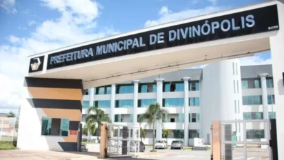 Entrada da Prefeitura Municipal de Divinópolis com pórtico branco, letreiro superior e prédio administrativo ao fundo sob céu azul. Foto: Divulgação/Divinópolis-MG