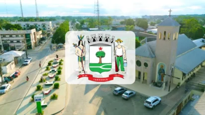 Vista aérea da cidade de Tarauacá, com o brasão do município centralizado sobre a imagem de ruas, praças e uma igreja.