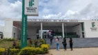 Fachada do Instituto Federal de Minas Gerais com totem do IFMG e estudantes subindo a escada rumo à entrada, representando a especialização EaD gratuita