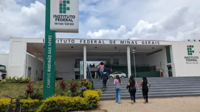 Fachada do Instituto Federal de Minas Gerais com totem do IFMG e estudantes subindo a escada rumo à entrada, representando a especialização EaD gratuita