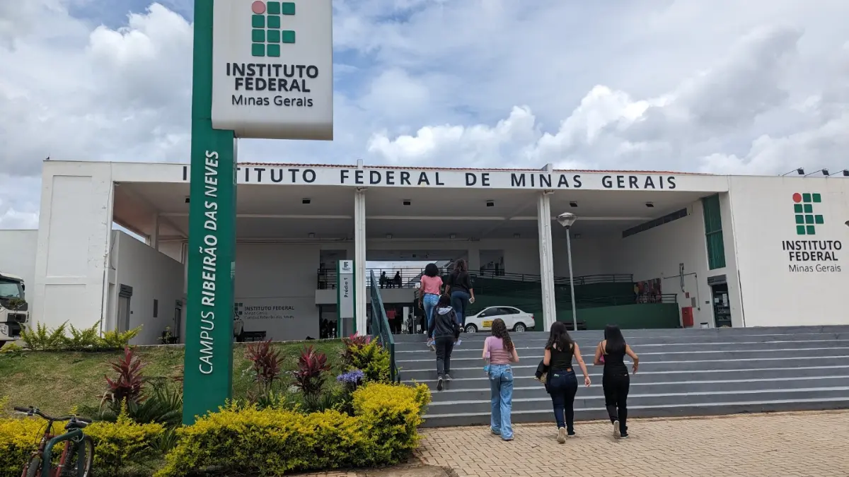Especialização EaD gratuita IFMG oferece 150 vagas em Administração Pública 1 Fachada do Instituto Federal de Minas Gerais com totem do IFMG e estudantes subindo a escada rumo à entrada, representando a especialização EaD gratuita