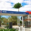 Portal de entrada da Universidade Estadual do Sudoeste da Bahia com faixa azul e estrutura vermelha exibindo o nome da instituição, representando a especialização EaD gratuita UESB em Gestão da Comunicação