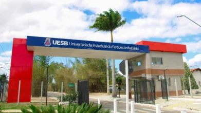 Portal de entrada da Universidade Estadual do Sudoeste da Bahia com faixa azul e estrutura vermelha exibindo o nome da instituição, representando a especialização EaD gratuita UESB em Gestão da Comunicação