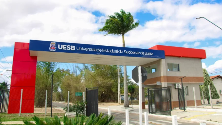 Portal de entrada da Universidade Estadual do Sudoeste da Bahia com faixa azul e estrutura vermelha exibindo o nome da instituição, representando a especialização EaD gratuita UESB em Gestão da Comunicação