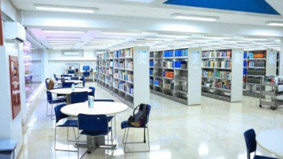 Biblioteca ampla e iluminada com estantes de livros, mesas redondas, cadeiras e computadores disponíveis para estudo. Foto: Jhonatan Cantarelle/Agência Saúde-DF