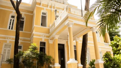 Sede da FUNCEB em Salvador vista em sua fachada histórica amarela com colunas brancas e área externa arborizada. Foto: Divulgação/FUNCEB