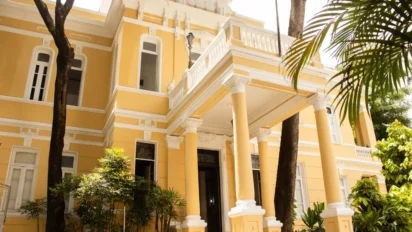 Sede da FUNCEB em Salvador vista em sua fachada histórica amarela com colunas brancas e área externa arborizada. Foto: Divulgação/FUNCEB