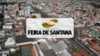Vista aérea da cidade de Feira de Santana, na Bahia, com o logotipo da Prefeitura Municipal sobreposto ao centro da imagem.