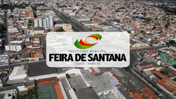 Vista aérea da cidade de Feira de Santana, na Bahia, com o logotipo da Prefeitura Municipal sobreposto ao centro da imagem.