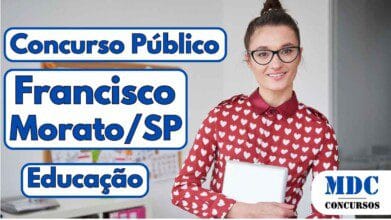 Mulher sorridente com óculos e coque no cabelo, vestindo camisa vermelha com estampa de corações brancos, segurando um notebook em um escritório com quadro de anotações ao fundo - Francisco Morato (SP) oferece remuneração de até R$ 4mil em Concurso na Educação