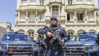 Guarda Municipal de Curitiba em frente a prédio histórico com viaturas e agentes fardados armados em posição de prontidão. Foto: Divulgação/Prefeitura de Curitiba
