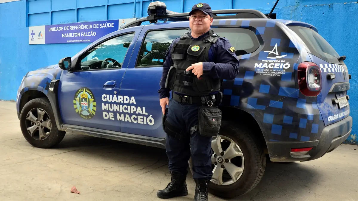 
O Gemini disse
Guarda civil uniformizado em pé ao lado de uma viatura azul da Guarda Municipal de Maceió, estacionada em frente a uma unidade de saúde. A viatura exibe o brasão da corporação e o logotipo da prefeitura.