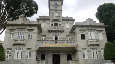 Garanhuns/PE abre processo seletivo com 300 vagas imediatas 3 Fachada do Palácio Celso Galvão, prédio histórico de Garanhuns, com arquitetura clássica, torre central com relógio e janelas simétricas em tom cinza claro. Foto: Hilton Marques/Arquivo Secom PMG