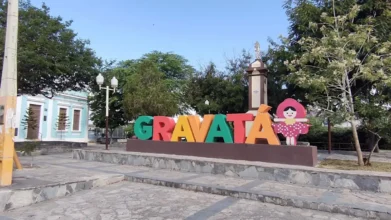 Letreiro colorido com o nome Gravatá em praça pública, com monumento, árvores e prédios históricos ao fundo em dia ensolarado. Foto: Divulgação/Google Maps (Andréa Vichi)