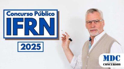 Homem de cabelos grisalhos, usando óculos, camisa branca e colete bege, segura uma caneta preta e aponta para um quadro branco ao lado do qual aparece o texto Concurso Público IFRN 2025 em letras azuis dentro de um retângulo com bordas azuis e marrons; no canto inferior direito está o logotipo MDC Concursos