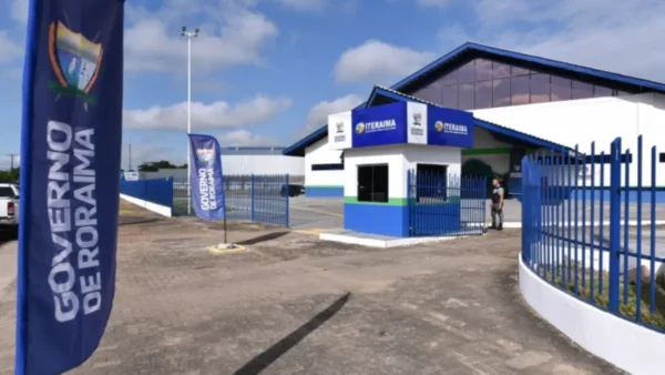ITERAIMA abre processo seletivo com 40 vagas imediatas de até R$ 8.745,85 2 Fachada da sede do ITERAIMA em Roraima, com prédio administrativo, guarita de entrada, bandeiras institucionais e portão azul sob céu aberto. Foto: Divulgação/Governo de Roraima