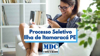 Mulher jovem sentada confortavelmente em um sofá branco, sorrindo enquanto olha o celular e segura um papel nas mãos. Ao fundo, há uma estante com livros e decoração em tons claros, transmitindo um ambiente doméstico e acolhedor. Sobre a imagem, há um banner com os dizeres "Processo Seletivo Ilha de Itamaracá PE" e a logomarca do site MDC Concursos.