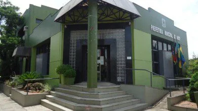 Prédio da Prefeitura Municipal de Ivoti, fachada verde com escadaria, bandeiras hasteadas e entrada principal ao centro. Foto: Divulgação/Prefeitura de Ivoti-RS