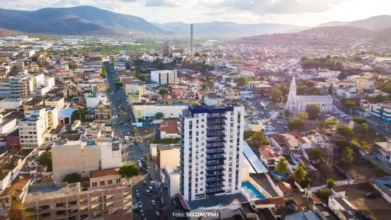 Jequié/BA lança concurso com 112 vagas de até R$ 4.182,98 3 Vista aérea do centro de Jequié, na Bahia, com prédios, ruas movimentadas e montanhas ao fundo em um dia ensolarado. Foto: Divulgação/Prefeitura de Jequié-BA