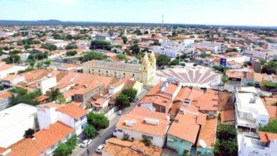 Processos Seletivos 9 Vista aérea de Limoeiro do Norte, no Ceará, com destaque para a igreja matriz, praça central e construções com telhados vermelhos ao redor.