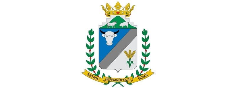 Serranópolis/GO abre seleção com 137 vagas de até R$ 4,5 mil 1 Brasão do município de Serranópolis-GO com coroa dourada, escudo dividido com imagens de boi, espigas de milho e carneiros, cercado por ramos verdes e faixa amarela com o nome do município e do estado.