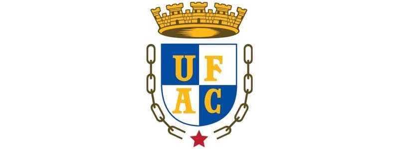 Concurso UFAC: 32 vagas com salários de até R$ 5 mil p/ TAE 1 Brasão da Universidade Federal do Acre com coroa dourada, escudo azul e branco com as letras UFAC em amarelo, corrente ao redor e estrela vermelha na base