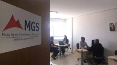 Sala da MGS com pessoas em atendimento e placa na porta indicando Unidade Regional Norte de Minas. Foto: Divulgação/MGS