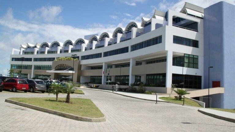 Prédio moderno do Ministério Público da Bahia com fachada envidraçada, estacionamento e bandeiras na entrada. Foto: Divulgação/MPBA