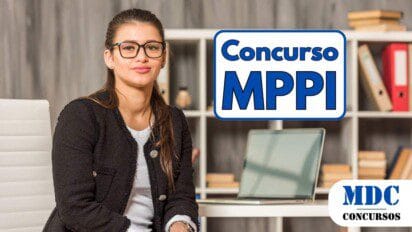 Mulher de óculos e cabelos longos castanhos, vestindo blazer preto e calça de couro, sentada em um escritório moderno com prateleiras ao fundo. Ela está ao lado de uma mesa branca com um laptop aberto, exibindo uma expressão confiante - MPPI abre 30 vagas com remuneração de até R$ 8,4 mil em novo Concurso