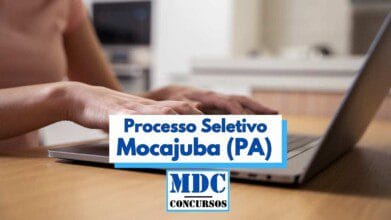 Processos Seletivos 8 Pessoa digitando em um notebook sobre uma mesa de madeira em ambiente doméstico, com destaque para um banner central que exibe o texto “Processo Seletivo Mocajuba (PA)” em letras azuis. Abaixo, aparece o logotipo “MDC Concursos”. A imagem remete à realização de inscrições online para concurso público, reforçando a ideia de acesso digital a processos seletivos.