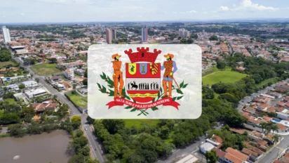 Vista aérea da cidade de Mogi Mirim com destaque para o brasão oficial do município centralizado em um retângulo branco translúcido sobre a paisagem urbana. Foto: Divulgação/Câmara Municipal de Mogi Mirim-SP