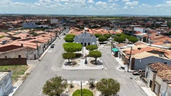 Monte Alegre de Sergipe abre concurso com 30 vagas p/ Guarda Municipal 4 Vista aérea de uma praça central arborizada com igreja ao fundo, rodeada por casas e comércios de telhados vermelhos em Monte Alegre de Sergipe. Foto: Divulgação/Governo de Sergipe