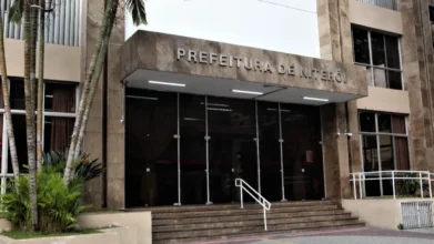 Niterói/RJ lança processo seletivo com salários de até R$ 6,9 mil na SMDH 3 Fachada da Prefeitura de Niterói com entrada de vidro, escadaria frontal, letreiro superior e vegetação ao lado do prédio. Foto: Divulgação/Berg Silva-Prefeitura de Niterói-RJ
