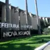 Fachada da Prefeitura Municipal de Nova Iguaçu com letreiro metálico em destaque e palmeiras ao redor. Foto: Divulgação/Prefeitura de Nova Iguaçu-RJ