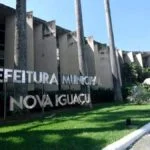 Fachada da Prefeitura Municipal de Nova Iguaçu com letreiro metálico em destaque e palmeiras ao redor. Foto: Divulgação/Prefeitura de Nova Iguaçu-RJ