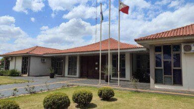 Processos Seletivos 6 Fachada da Prefeitura de Nova Santa Rosa, PR, com jardim em frente, bandeiras hasteadas e céu com nuvens ao fundo. Foto: Divulgação/Prefeitura de Nova Santa Rosa-PR