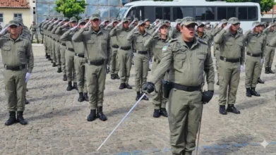 Formação de policiais militares da PMRN em continência durante cerimônia de instrução com oficial à frente segurando espada.