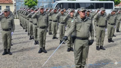 Formação de policiais militares da PMRN em continência durante cerimônia de instrução com oficial à frente segurando espada.